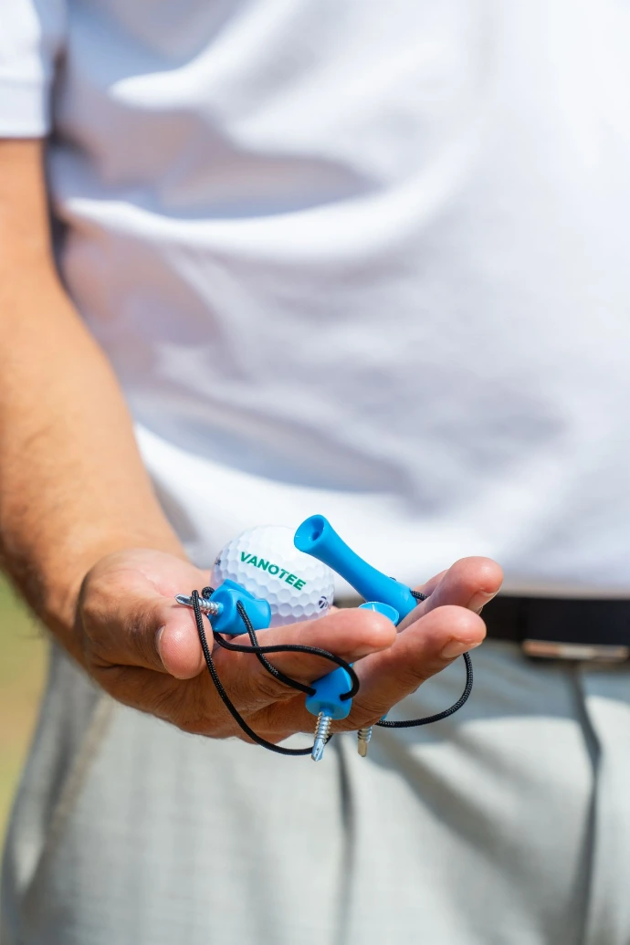 Tee de golf Vanotee tenu dans une main avec balle de golf vanotee